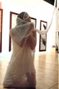 Blind dancer shrouded in white fabric